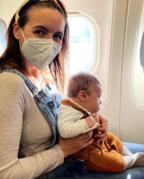 Mariangels con su bebé en brazos, sentada en el avión